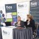 The Fios stand at the San Diego Conferences. Dr Sarah Lynagh and Kristen Laudicina sit at the table in front of the stand.