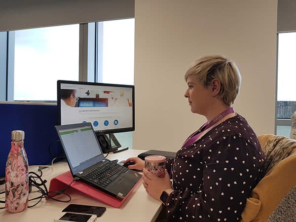 Lucy Kempsell - Fios Project Manager - at her desk.