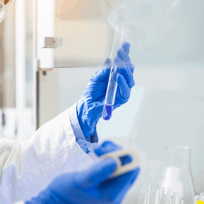 Hands holding test tube with blue liquid in